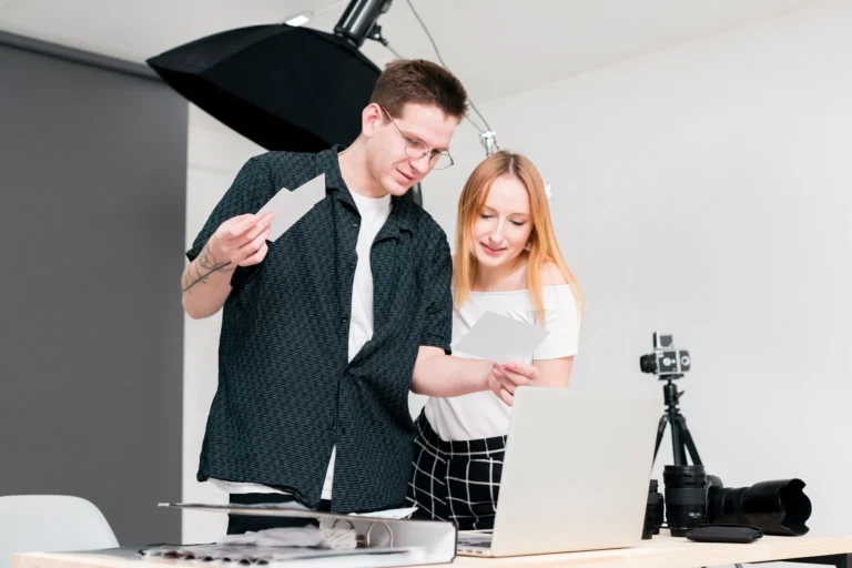 woman-man-looking-through-photos-studio_23-2148424